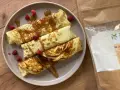 Naleśniki z malinami i syropem, obok paczka mąki bambusowej. Idealne przepisy na zdrowe śniadanie.