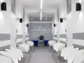 Nowoczesny korytarz poczekalni w centrum medycznym z białymi krzesłami i drzwiami.