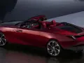 Czerwony kabriolet Rolls-Royce, najdroższe auto na świecie, lśni przy wodzie.