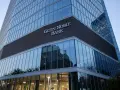 Nowoczesny budynek banku z napisem "GETIN NOBLE BANK". W szklanej fasadzie odbijają się inne budynki i drzewa.
