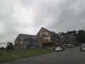 Nowoczesny hotel z drewnianymi elementami i kamienną elewacją. Na trawniku plac zabaw. Wiele pozytywnych osada-sniezka opinie potwierdza jego urok.