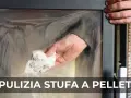 Mano che pulisce il vetro di una stufa a pellet con un panno sporco di fuliggine.