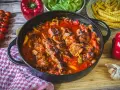 Herzhaftes Schaschlik-Rezept in Gusseisenpfanne mit Paprika, Zwiebeln und Tomaten. Dazu Pommes und frische Zutaten.