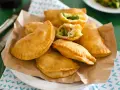 Panzerotti al forno dorati e ripieni di verdure, serviti su carta da forno.