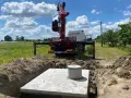 Montaż szamba betonowego w wykopie. Dostępne różne rodzaje szamb, ten jest w trakcie instalacji.