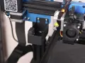 Zbliżenie na drukarkę 3D Sovol SV04, widoczny uchwyt na narzędzia przy głowicy drukującej.
