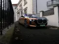 Eleganckie BMW i7 w miedzianym kolorze, zaparkowane przed willą. Ten luksusowy samochód elektryczny oferuje imponujący zasięg, pozwalając na długie podróże.