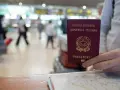 W podróży na Wyspy Kanaryjskie, czy na wyspy kanaryjskie potrzebny jest paszport? W ręku włoski paszport, na tle lotniska.