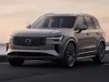 Elegancki, szary Volvo XC90 T8 sunie po drodze przy zachodzie słońca.