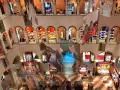 Interno del Fondaco dei Tedeschi, con archi, negozi e grandi stampe appese.