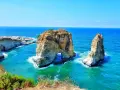 The Raouché sea stacks, iconic natural landmarks and historical sites in Lebanon, stand majestically against the bright blue Mediterranean Sea.
