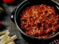 Herzhafte bolognese italienisch Soße in einem Topf, dane frische Pasta, Karotte und Sellerie.