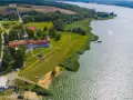 Widok z lotu ptaka na **zalew domaniow** z hotelem, plażą, kajakami i łodziami.