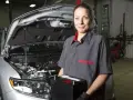Meccanica sorridente con una nuova batteria, pronta per mostrare come montare una batteria auto.