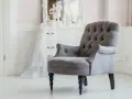Elegante sillón gris con botones, ideal para un tocador. ¿Cuánto vale tapizar una silla así?