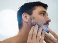 Hombre aplicándose espuma para quitarse la barba.