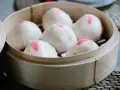 Pierożki baozi w bambusowym parowniku, gotowe do podania.