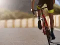 Cyclist in neon-accented shorts and polka-dot socks powering up a hill, embodying a dedicated sprint workout plan.