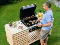 Man grillar på ett fint grillbord i trä. Perfekt för att bygga ett eget grillbord för sommarens fester.