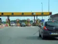 Bramki autostrady A1 z samochodami zbliżającymi się do punktu poboru opłat.