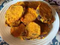 Fette dorate di melanzane in friggitrice ad aria, impanate e croccanti, servite su un piatto bianco.