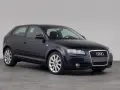 Dunkelblauer Audi A3 1.9 TDI Dreitürer steht auf grauem Boden vor hellem Hintergrund.