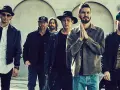 Sechs Männer der Band Linkin Park stehen nebeneinander, einige tragen Hüte und Jacken.