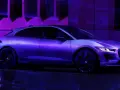 Jaguar I-Pace w fioletowym świetle, zaparkowany na mokrej nawierzchni.