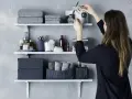 Idee mensole ingresso: organizzazione bagno con asciugamani grigi, scatole e cestini in maglia.
