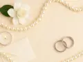 Biała gardenia, świeca, koperta i obrączki symbolizują 10 rocznicę ślubu.