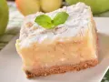 Pyszne, ekspresowe ciasto z jabłkami, posypane cukrem pudrem i udekorowane listkiem mięty. Idealne na szybki deser.