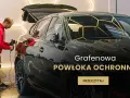 Mężczyzna poleruje czarny samochód, nakładając powłokę grafenową dla ochrony i blasku.
