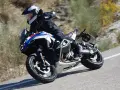 Motociclista in sella a una BMW GS 1300, che affronta una curva su strada sterrata, sfiorando la velocità massima.