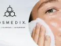 A woman's face is gently cleansed with a white pad, showcasing the benefits of enzyme exfoliation for radiant skin.