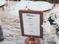 Eleganckie menu na wesele w miedzianej ramce, z włoskimi daniami: Antipasti, Secondi, Dolci.
