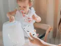 Niña interactúa con humidificador mientras una mano controla la app para humidificar el ambiente.