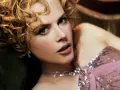 Nicole Kidman w różowej, cekinowej sukni, z burzą blond loków. Jej spojrzenie przywodzi na myśl jej niezapomniane role w filmach.