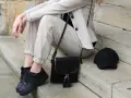 Stylisches flugzeug outfit damen: beige Hose, Blazer, schwarze Sneaker, Tasche und Cap. Perfekt für die Reise.