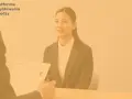 Kobieta na rozmowie kwalifikacyjnej, przed nią leżą dokumenty aplikacyjne.