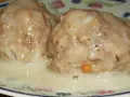 Dwa duże, apetyczne klopsy w kremowym sosie, przypominające smak zupy klopsowej babci.