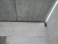 Betonowy strop z widocznym pęknięciem nad ścianą z białych pustaków.