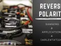 Close-up of battery terminals and cables, with text overlay warning about reverse polarity dangers.