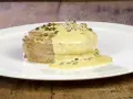 Un succulento filetto al pepe verde, ricoperto da una cremosa salsa, servito su un piatto bianco.