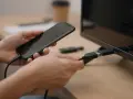 Ręce łączą smartfon z telewizorem za pomocą kabla USB-C. Dowiedz się, jak połączyć się z telewizorem, by cieszyć się większym ekranem.