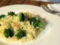 Delicioso arroz con brócoli cremoso, servido en un plato blanco con un tenedor al lado.