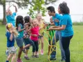 Des enfants et des animateurs jouent à la corde à sauter dans un parc.
