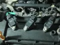 Three ignition coils are visible on a black engine cover, ready for testing.