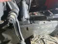 Elementy mechaniczne ciągnika Ursus C-360 podczas remontu skrzyni biegów. Widać ślady oleju i narzędzia.
