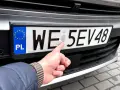 Palec wskazuje hologram na tablicy rejestracyjnej. Zastanawiasz się, ile kosztują tablice rejestracyjne?