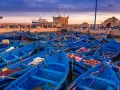 Port w Maroku, pełen błękitnych łodzi rybackich, z twierdzą w tle. Idealna pogoda na wrzesień, by podziwiać zachód słońca nad Atlantykiem.